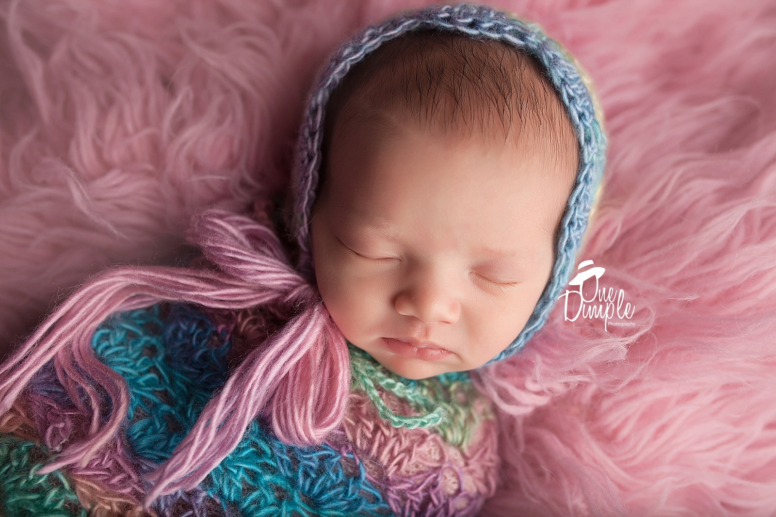 Newborn wrapped in colorful sack