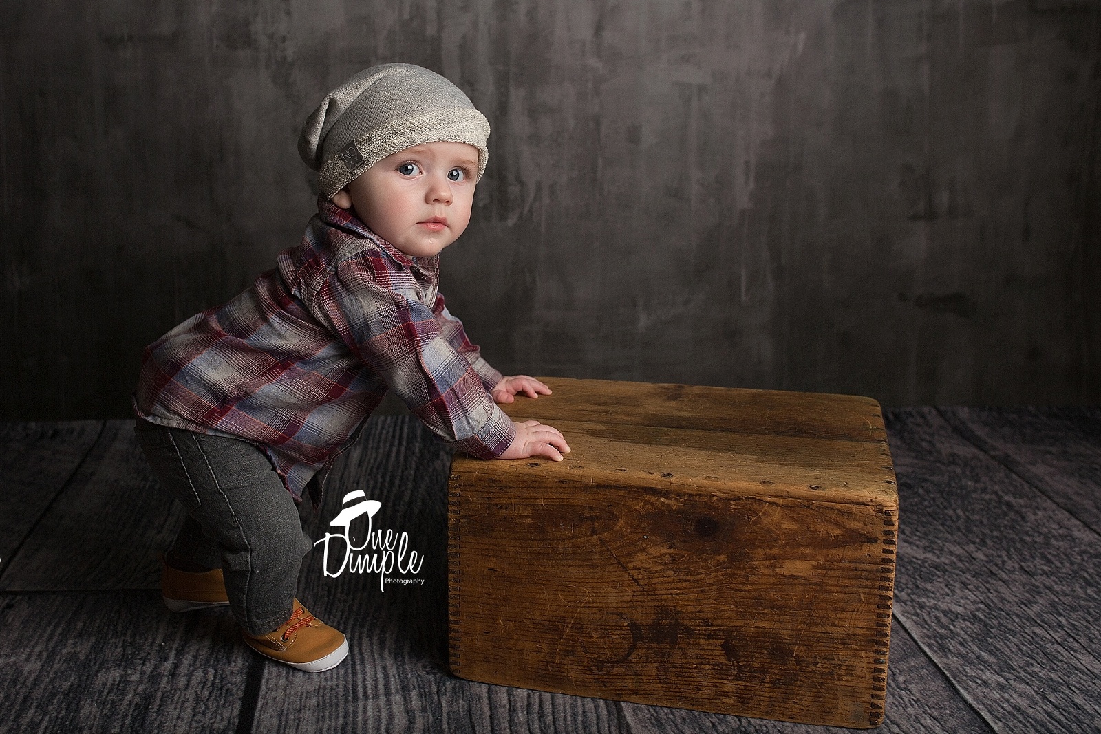 6 month old standing against a wooden box