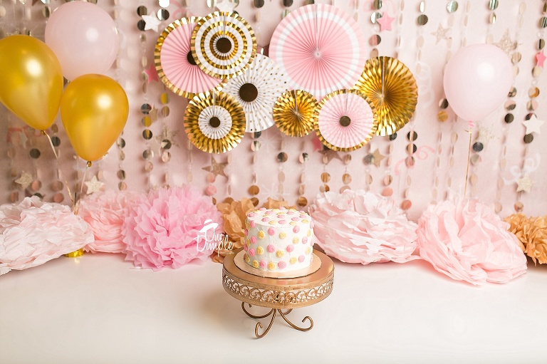 One Dimple Photography is a custom cake smash photographer for Dallas Fort Worth.  Simple Gold and pink custom cake smash 