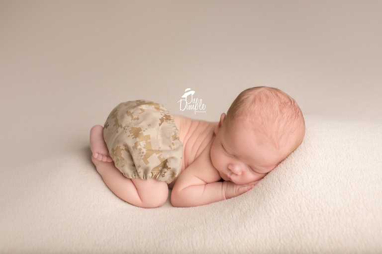 One Dimple Photography is a DFW, Southlake, Trophy Club, Grapevine, Argyle newborn photographer. In-Home Newborn Session baby in Military outfit.