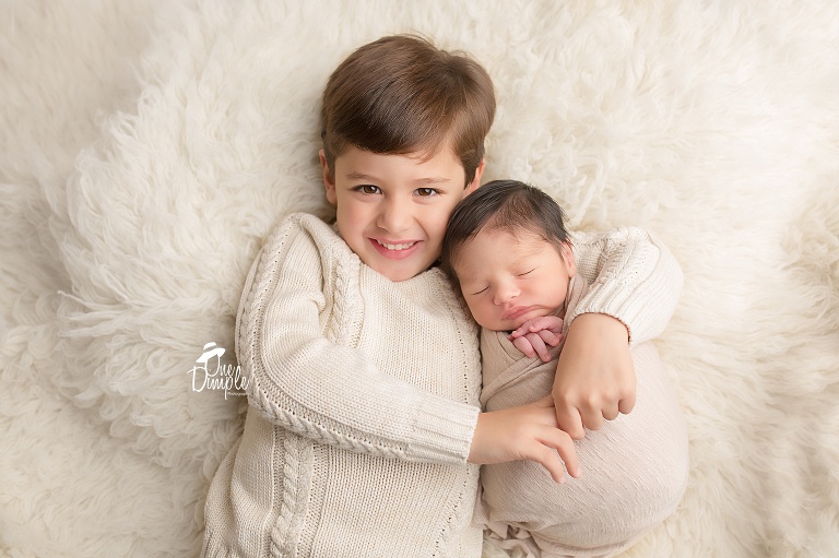 One Dimple Photography is a DFW, Southlake, Trophy Club, Grapevine, Keller newborn photographer. In-Home Newborn Session with neutral brother and newborn pose